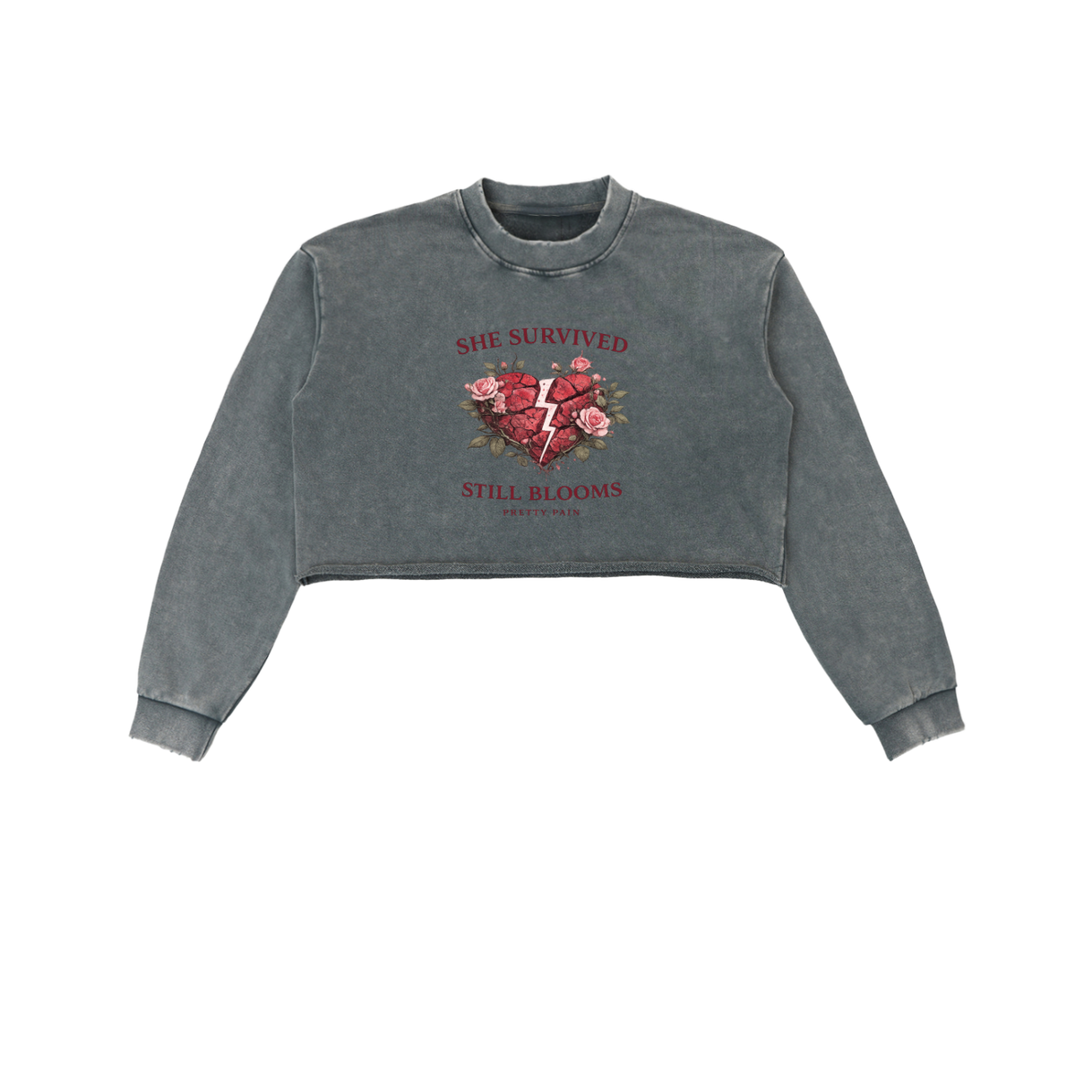 Built From Pain She Survived Still Blooms cropped sweatshirt with floral design and bold text on soft fabric.