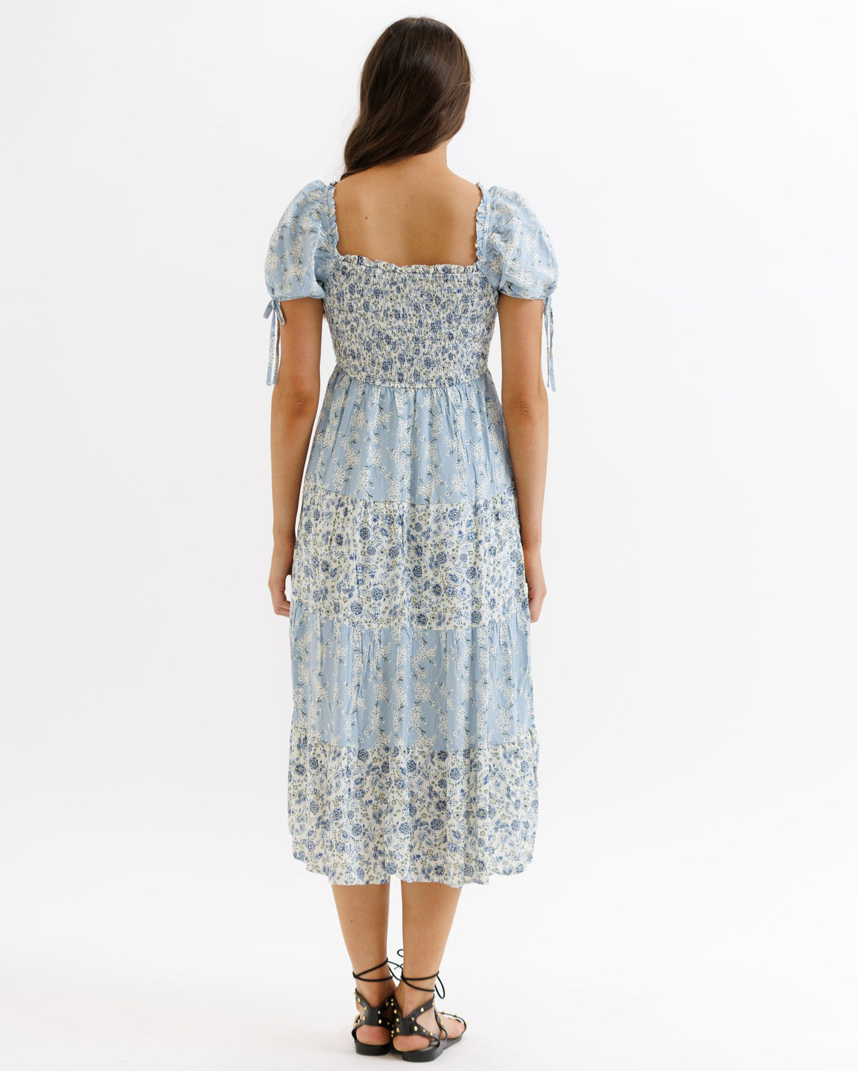 Light blue multi-pattern Fresh Bouquet dress by Downeast, featuring a floral design and flowing fabric, displayed on a hanger.