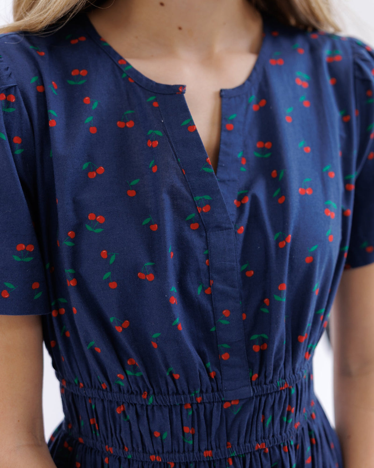 Downeast Icon Demi Dress with floral pattern, sleeveless design, and fitted waist on a hanger.