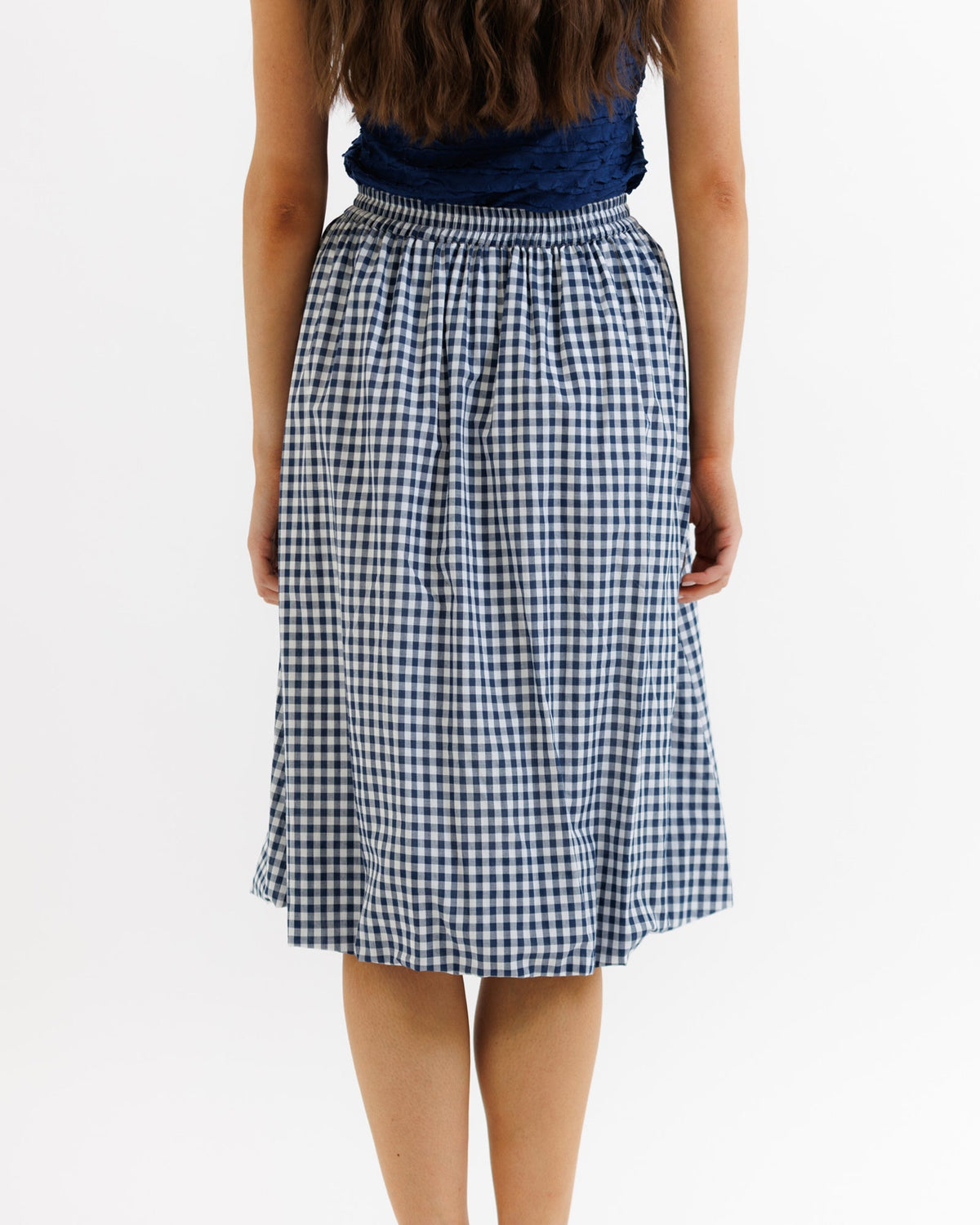 Navy check bubble skirt from Downeast, casual and stylish, shown in a close-up image with pleated design and versatile length