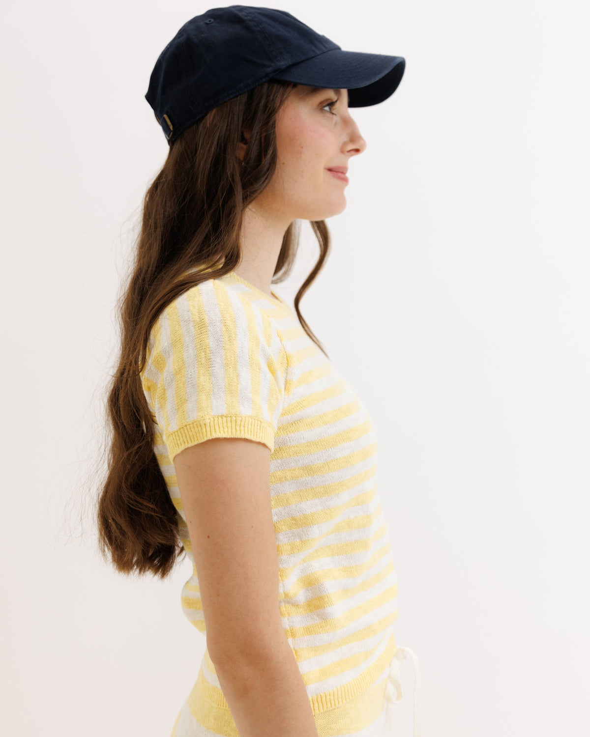 Yellow striped Downeast Round Trip Crew sweater displayed on a hanger, showcasing its cozy knit and casual style.