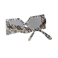 Close-up of Madame X sunglasses from Exclusive Eyes Inc., showcasing sleek black frames and tinted lenses.