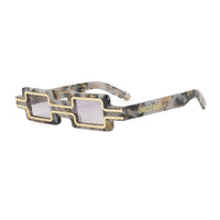 Close-up of the EXCLUSIVE EYES CREATOR sunglasses showing black frames and tinted lenses on a neutral background.