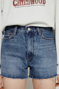 High rise denim shorts by Hey Joanie with a distressed finish and frayed hem, styled on a model for a casual summer look.