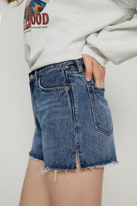 High-rise denim shorts by Hey Joanie with a light wash and frayed hem, styled with a casual summer look.