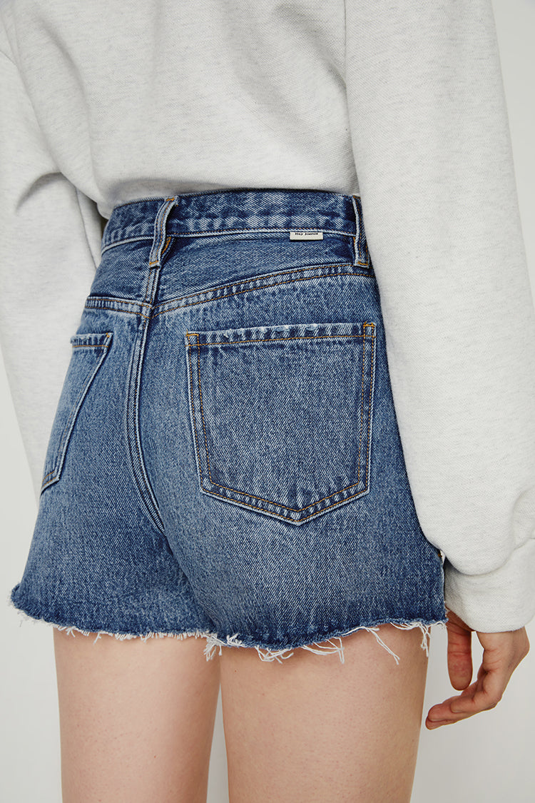 High rise denim shorts by Hey Joanie, featuring a classic blue wash and distressed details, displayed on a model.