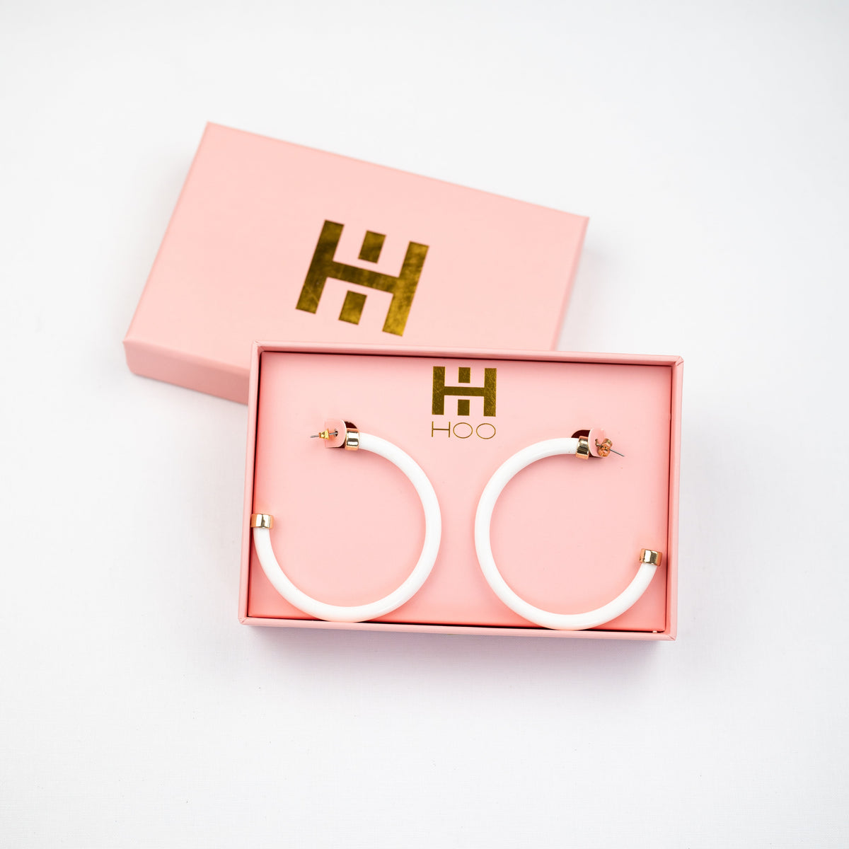White hoop earrings by hoohoops featuring classic circular design, stylish jewelry accessory for everyday wear.