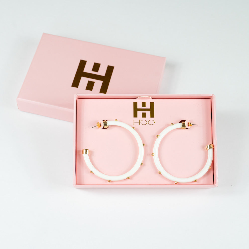 White hoop earrings with gold ball accents, stylish hoohoops jewelry featuring a sleek, modern design and gold detailing.