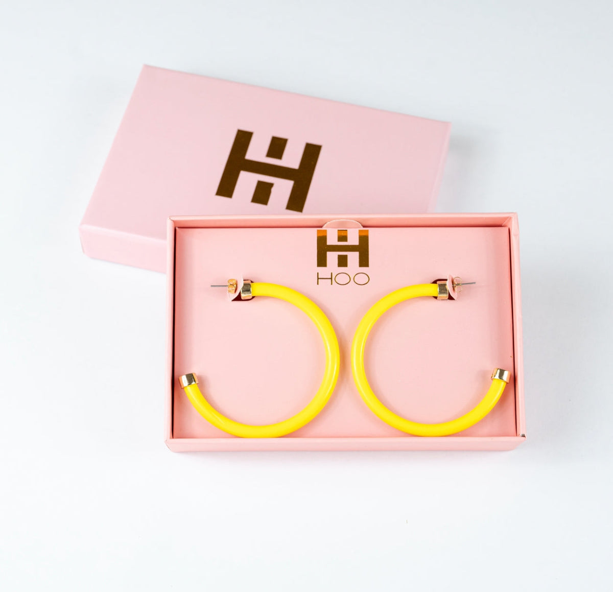 Yellow hoop earrings by hoohoops, showcasing shiny gold-tone hoops with a smooth circular design, perfect for stylish accessories.