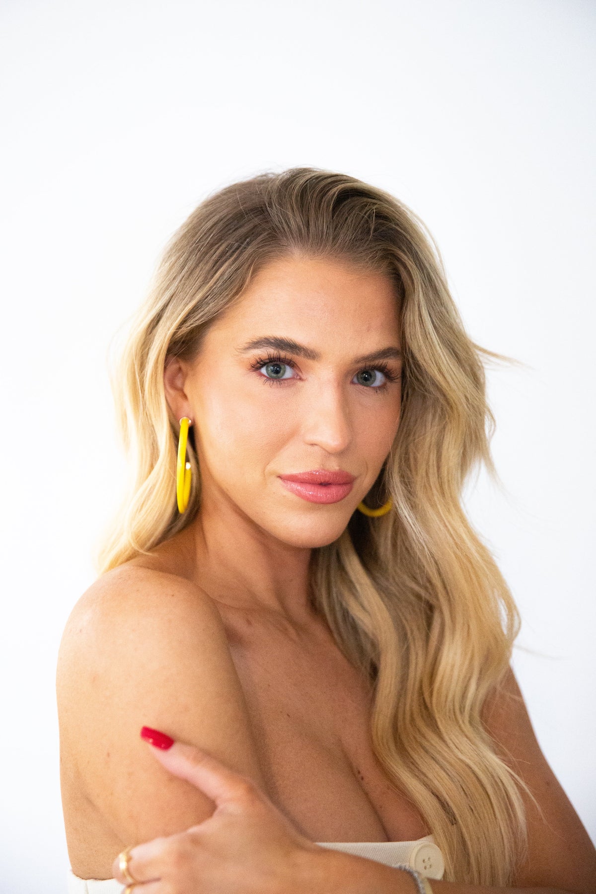 Yellow hoop earrings by hoohoops featuring large, circular gold-toned hoops hanging from a simple hook design.