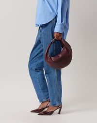 HYER GOODS burgundy ring hobo bag with circular handle and soft leather material, stylish and spacious for everyday use.