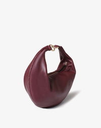 HYER GOODS Burgundy Ring Bag, a stylish hobo bag with a circular ring detail and no strap, showcasing its textured leather design.