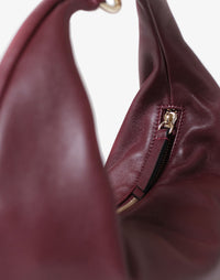 HYER GOODS burgundy ring hobo bag with circular handle and soft leather texture.