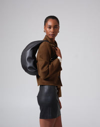 Black and gold hobo bag from HYER GOODS featuring a distinctive ring handle and soft leather material.