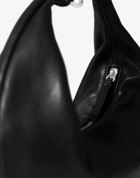 HYER GOODS black leather Ring Bag with silver ring detail, stylish hobo bag featuring a slouchy silhouette and adjustable strap.