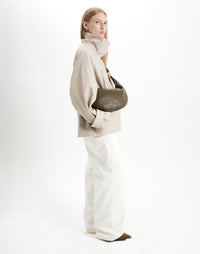 Olive nappa leather hobo bag by HYER GOODS with a ring detail, worn crossbody style, showcasing the stylish and functional design.