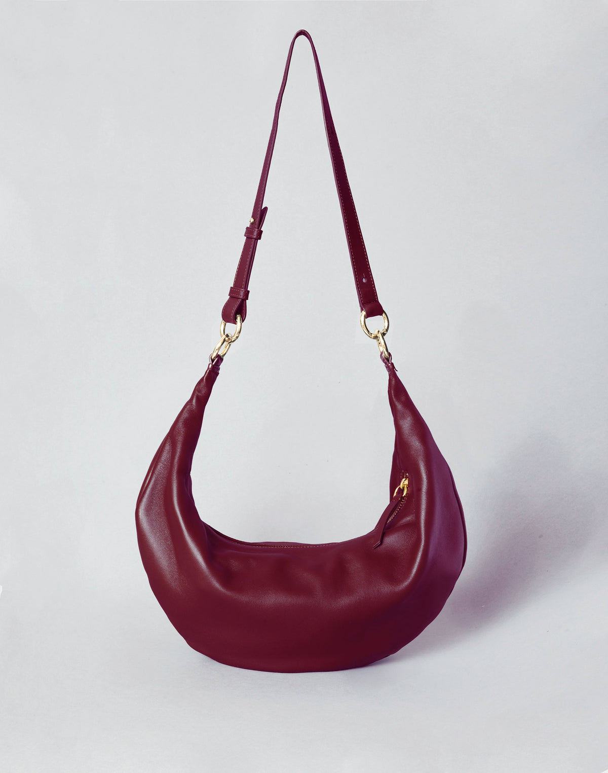 HYER GOODS Ring Bag in Bordeaux with long strap, hobo style, featuring a rounded ring design and soft leather texture.