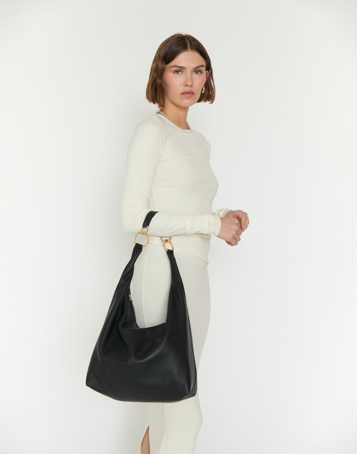 Black and gold HYER GOODS Hobo Ring Bag with rounded shape and adjustable strap, made of soft leather.
