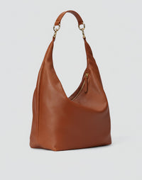 HYER GOODS Hobo Ring Bag in cognac leather with a rounded silhouette and ring detail, showing the front view.