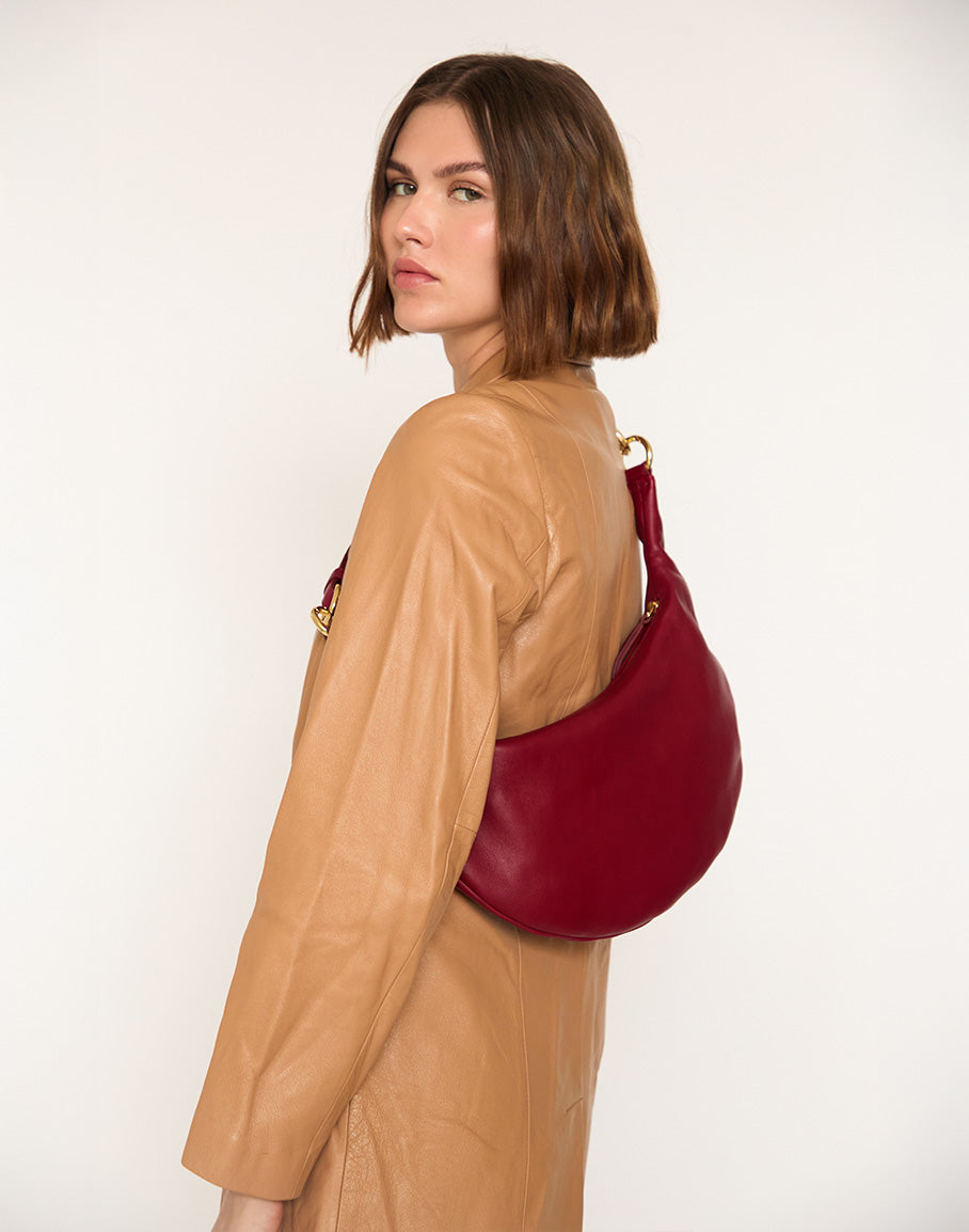 Cherry red HYER GOODS Piccola Ring Bag hobo bag with circular handle and compact design, shown in a stylish side view.