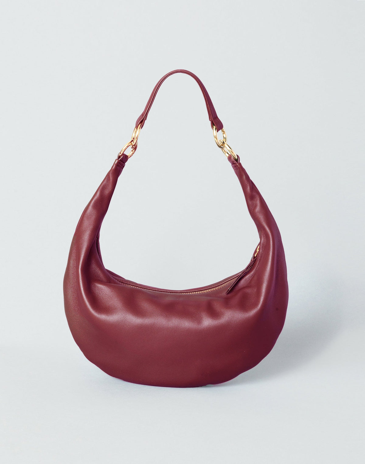 Red Piccola Ring Bag by HYER GOODS, a compact hobo bag with a sleek design and a distinctive ring detail.