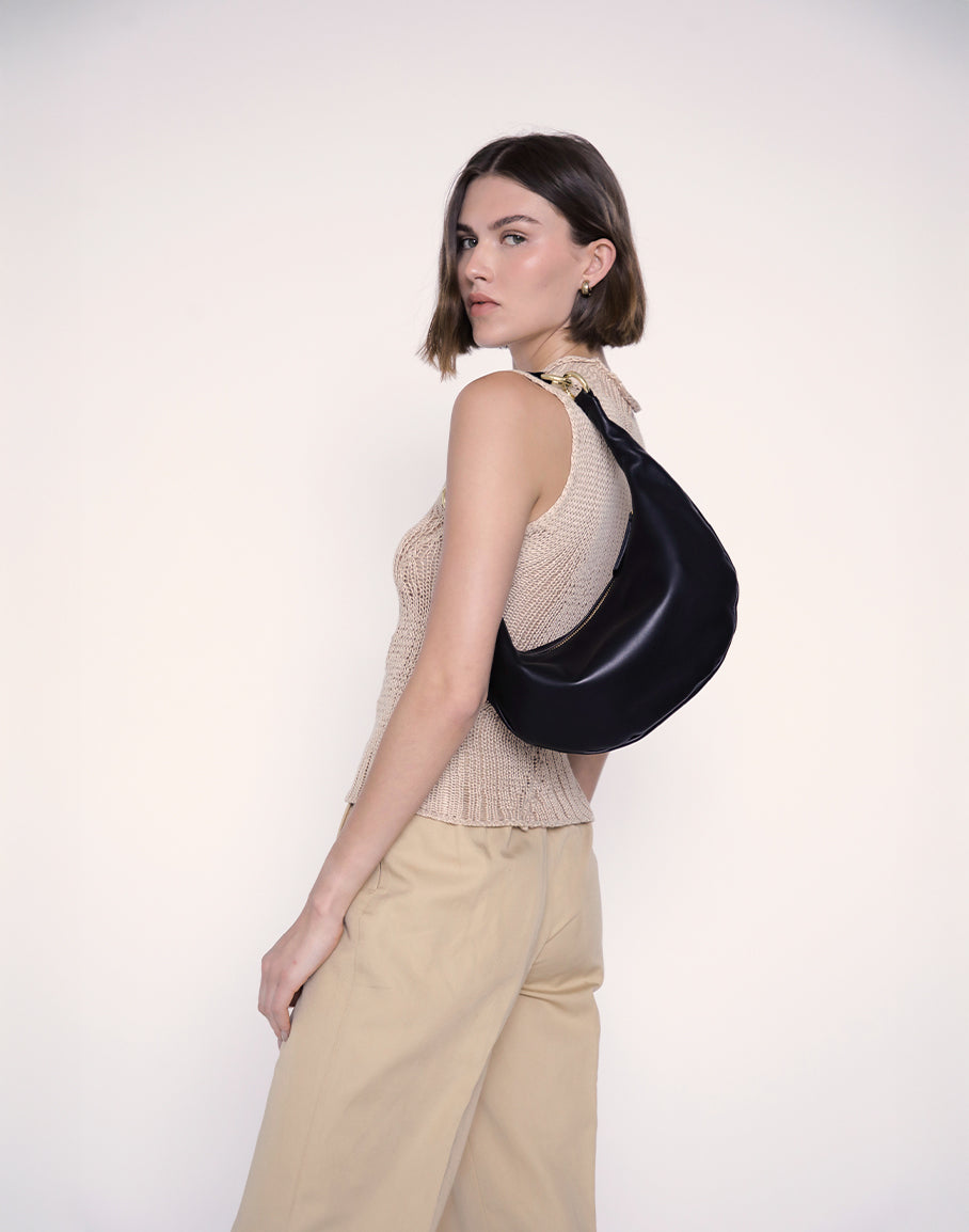 HYER GOODS Piccola Ring Bag hobo bag in black leather with gold hardware, featuring a stylish, compact design with a ring handle.