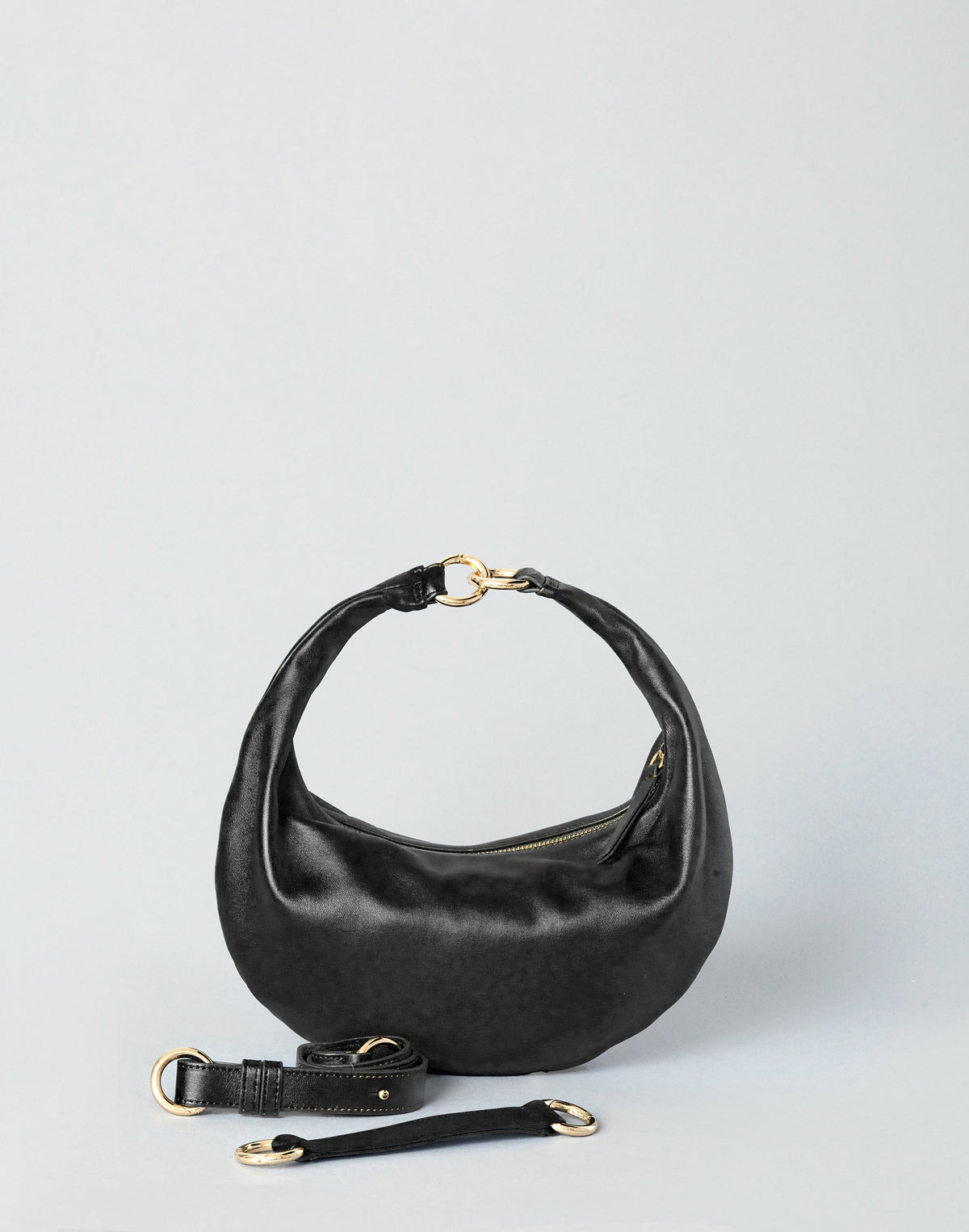 Black and gold Piccola Ring Bag by HYER GOODS, a stylish hobo bag with a sleek design and ring detail.