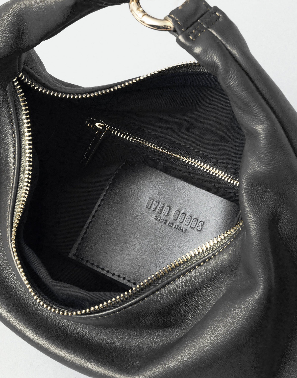 HYER GOODS Piccola Ring Bag hobo bag in black with gold accents, shown open with interior details.