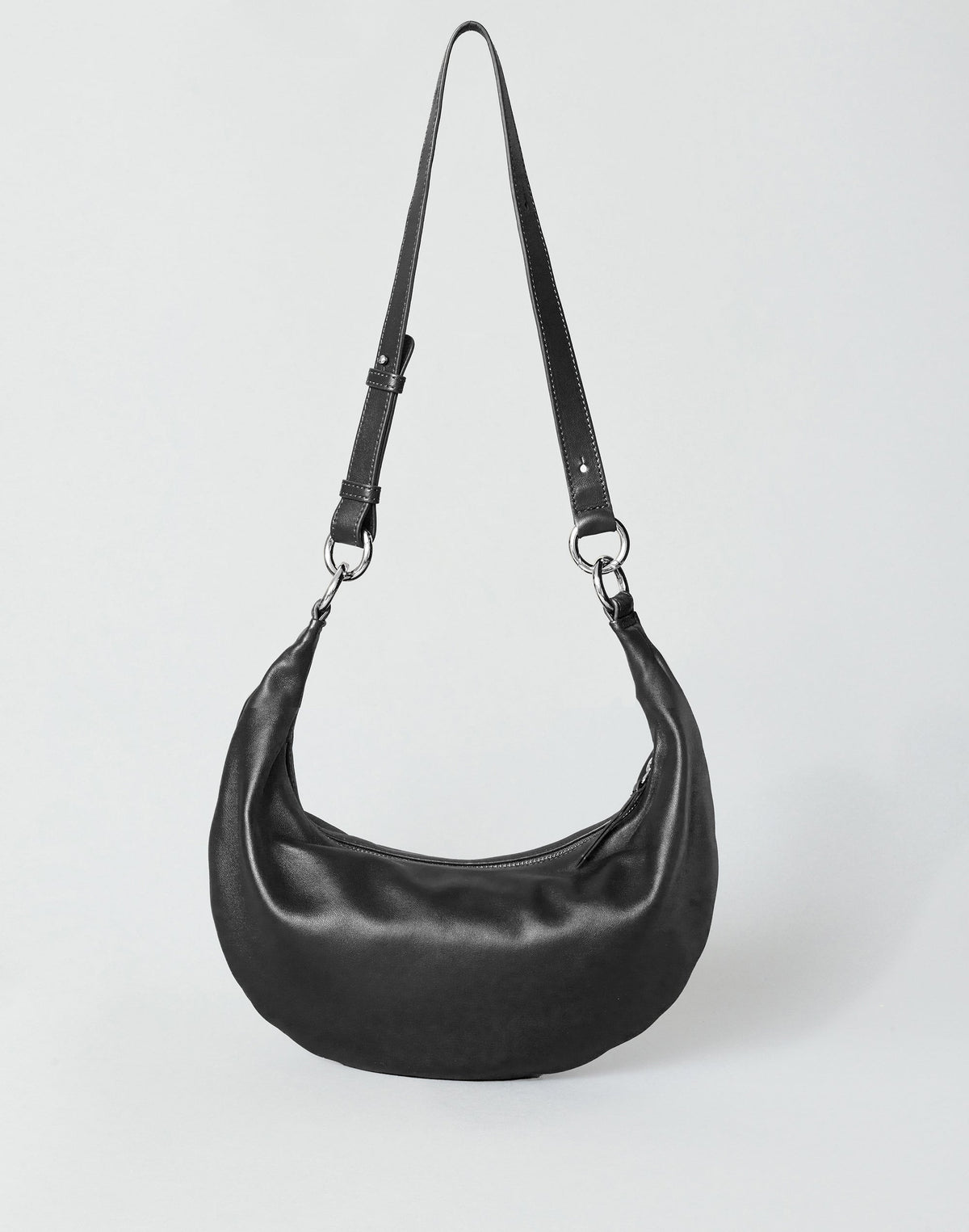 Black and silver Piccola Ring Bag by HYER GOODS, a stylish hobo bag with a circular ring design and crossbody strap.