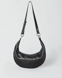 Black and silver Piccola Ring Bag by HYER GOODS, a stylish hobo bag with a circular ring design and crossbody strap.