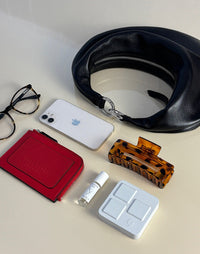HYER GOODS Piccola Ring Bag hobo bag in black with silver hardware, showing its compact size and what fits inside.