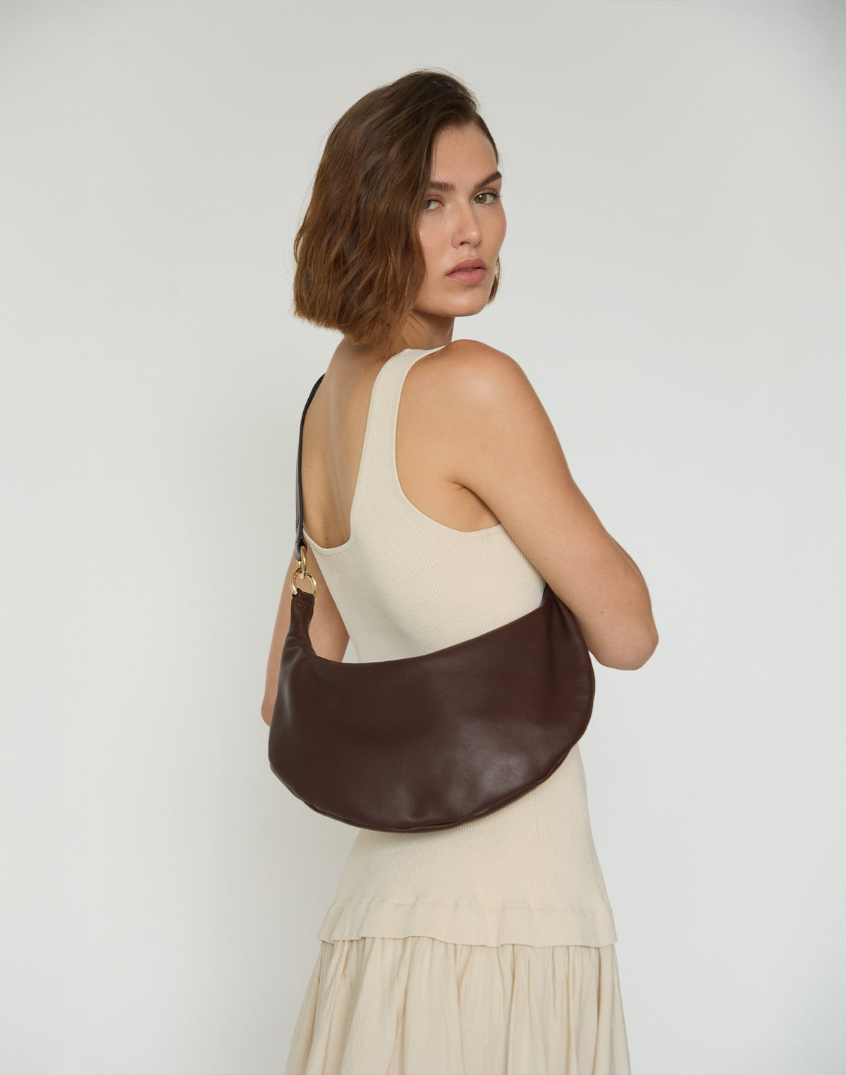 HYER GOODS Piccola Ring Bag hobo bag in chocolate leather with circular ring detail and adjustable strap.
