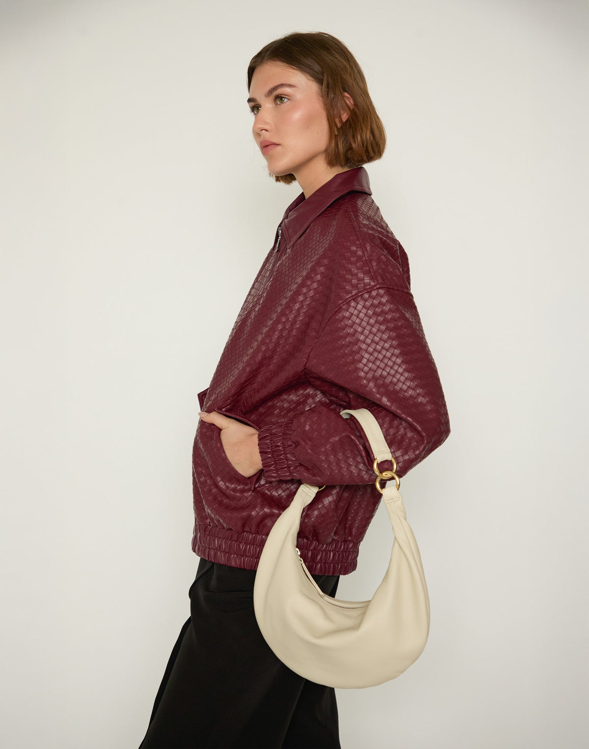 Hyer Goods Piccola Ring Bag hobo bag in off-white with circular handle and minimalist design, showing front view on a plain background.