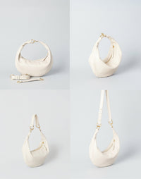 HYER GOODS Piccola Ring Bag hobo bag in off-white leather with a distinctive ring handle and versatile 4-way carry options.
