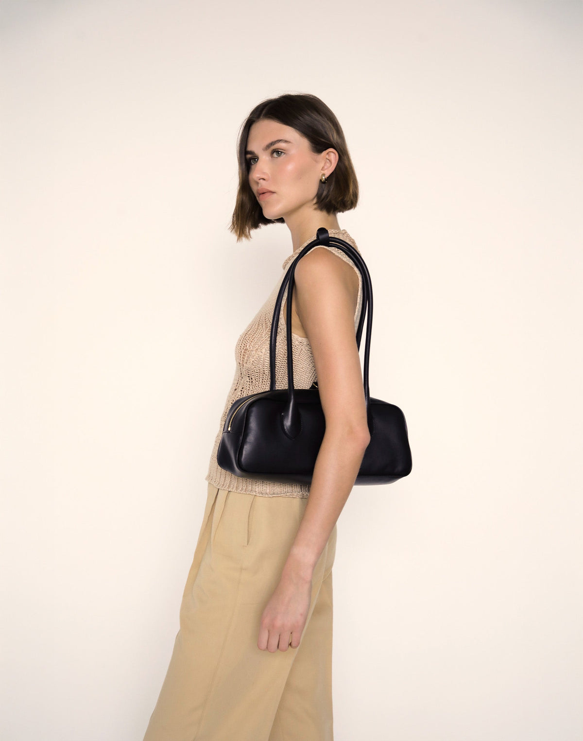 Black La Strada East West Shoulder Bag by HYER GOODS with sleek design and spacious interior, shown from side view.