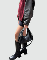 HYER GOODS Mini Everyday Shoulder Bag in black with gold accents, shown in a handheld view with grey background.