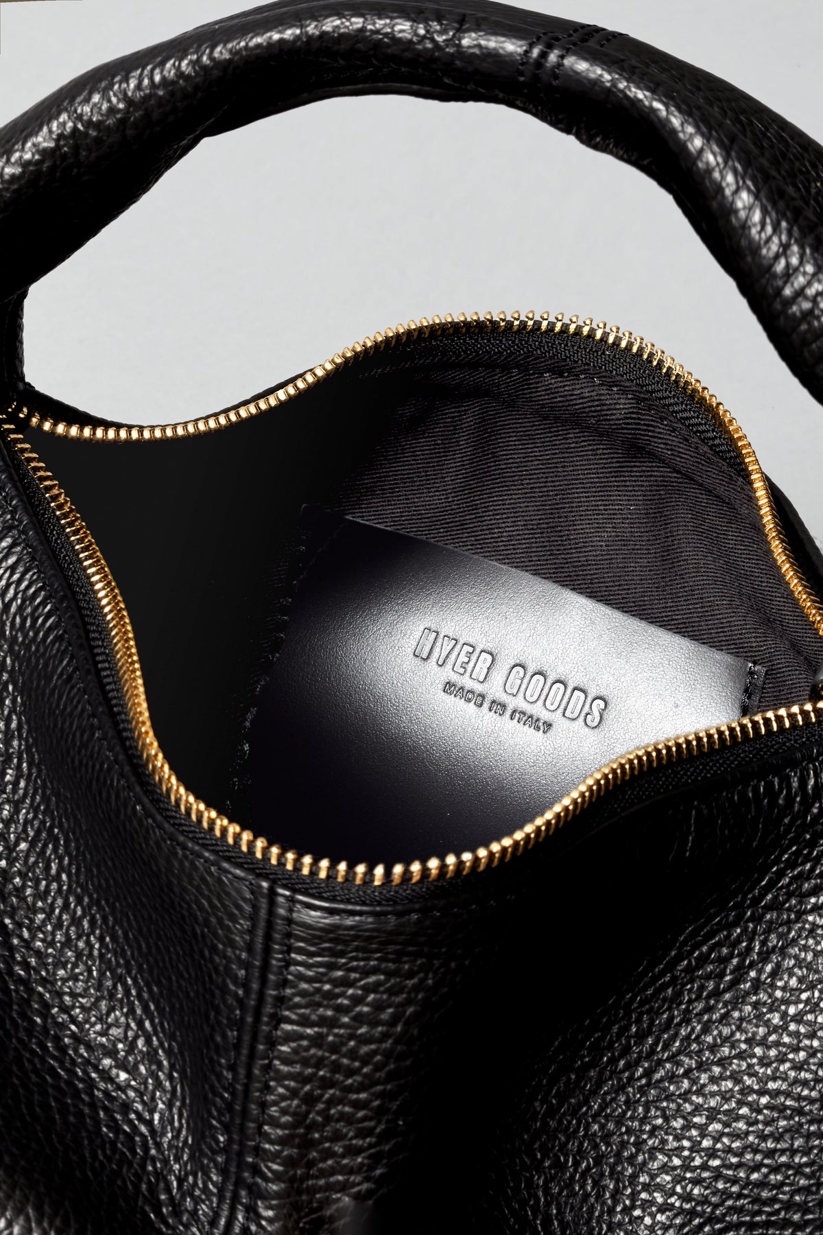 Black and gold Mini Everyday Shoulder Bag by HYER GOODS, showing its compact design and stylish shoulder strap.