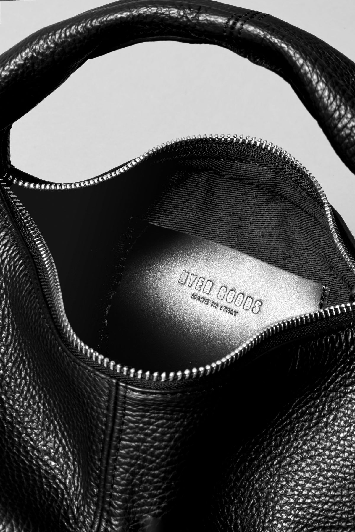 Black mini everyday shoulder bag by HYER GOODS with silver hardware, featuring a compact design and adjustable strap.