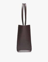 HYER GOODS Tolentino Tote Bag in double-face chocolate leather, showing side view of stylish, spacious tote with smooth finish.