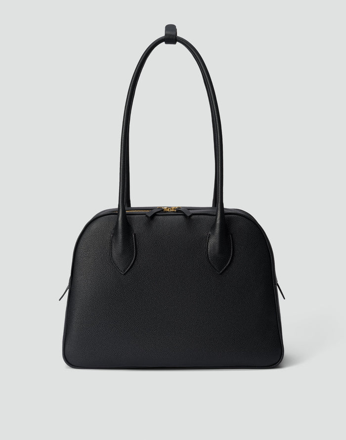 HYER GOODS La Autostrada tote bag in black and gold with sturdy handles and spacious interior on a plain background.
