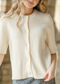 Ivory short sleeve button cardigan from Inherit Co.'s Zadie IC Layering Essentials collection, shown on a model.