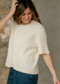 Ivory short-sleeve button cardigan from Inherit Co.'s Zadie IC Layering Essentials collection, displayed on a plain background.