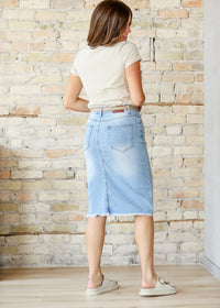 Inherit Co. Drew Raw Hem Midi Denim Skirt featuring a classic blue wash and raw hem detail, styled with casual tops.