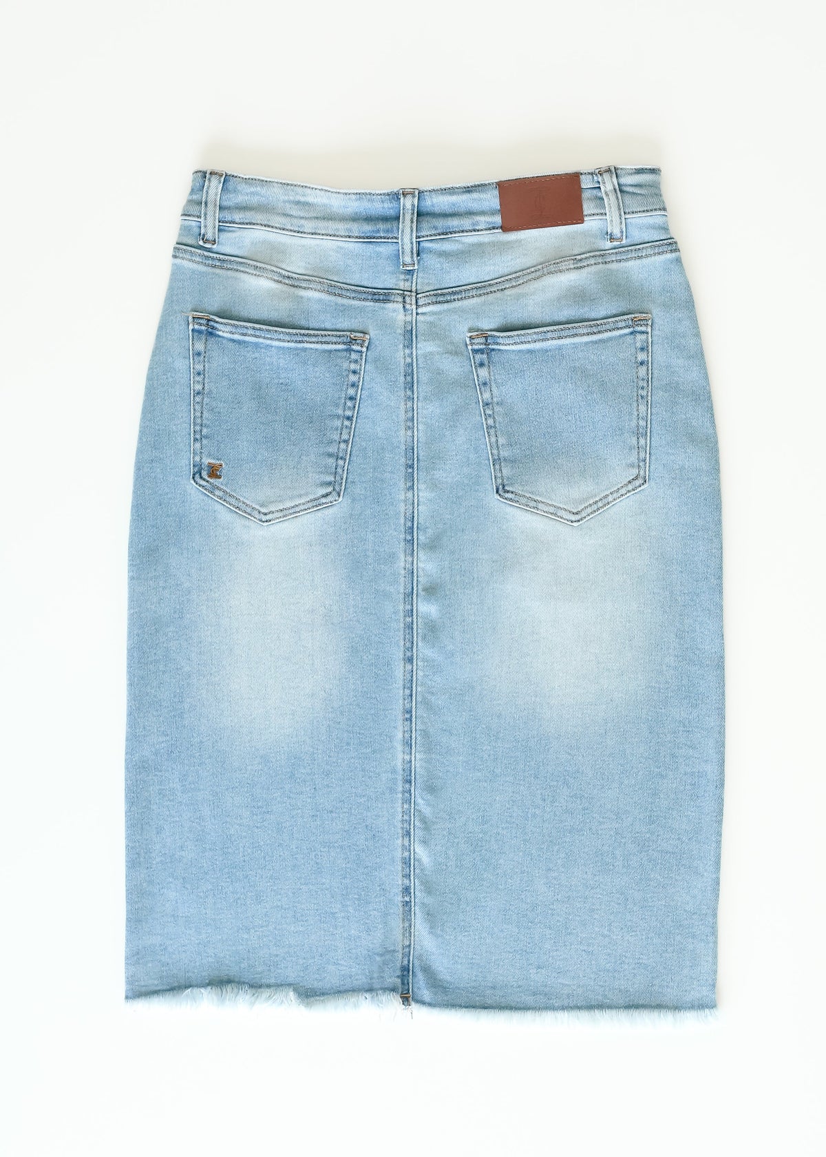 Inherit Co. Drew Raw Hem Midi Denim Skirt with front pockets and faded blue wash, displayed on a plain background.