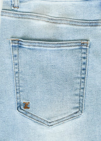 Inherit Co. Drew Raw Hem Midi Denim Skirt with a casual, distressed hem, showcased on a model styled for everyday wear.