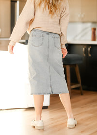 Light wash midi denim skirt from Inherit Co. featuring a classic fit and versatile style, perfect for casual or chic outfits.
