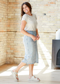 Light wash midi denim skirt by Inherit Co., featuring a classic fit and stylish length, perfect for casual or chic outfits.
