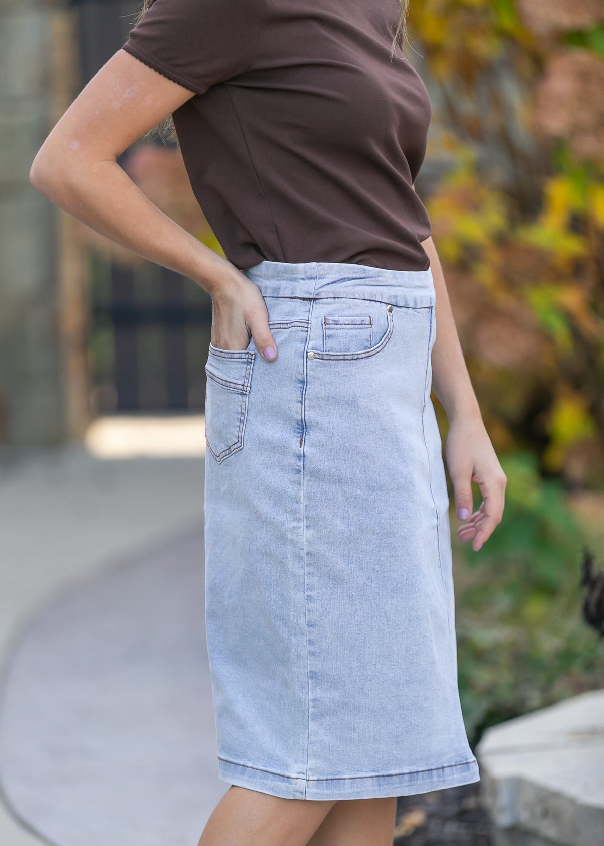 Inherit Co. Sandra light wash denim midi skirt, casual style with a flattering fit, shown on a model against a neutral background.