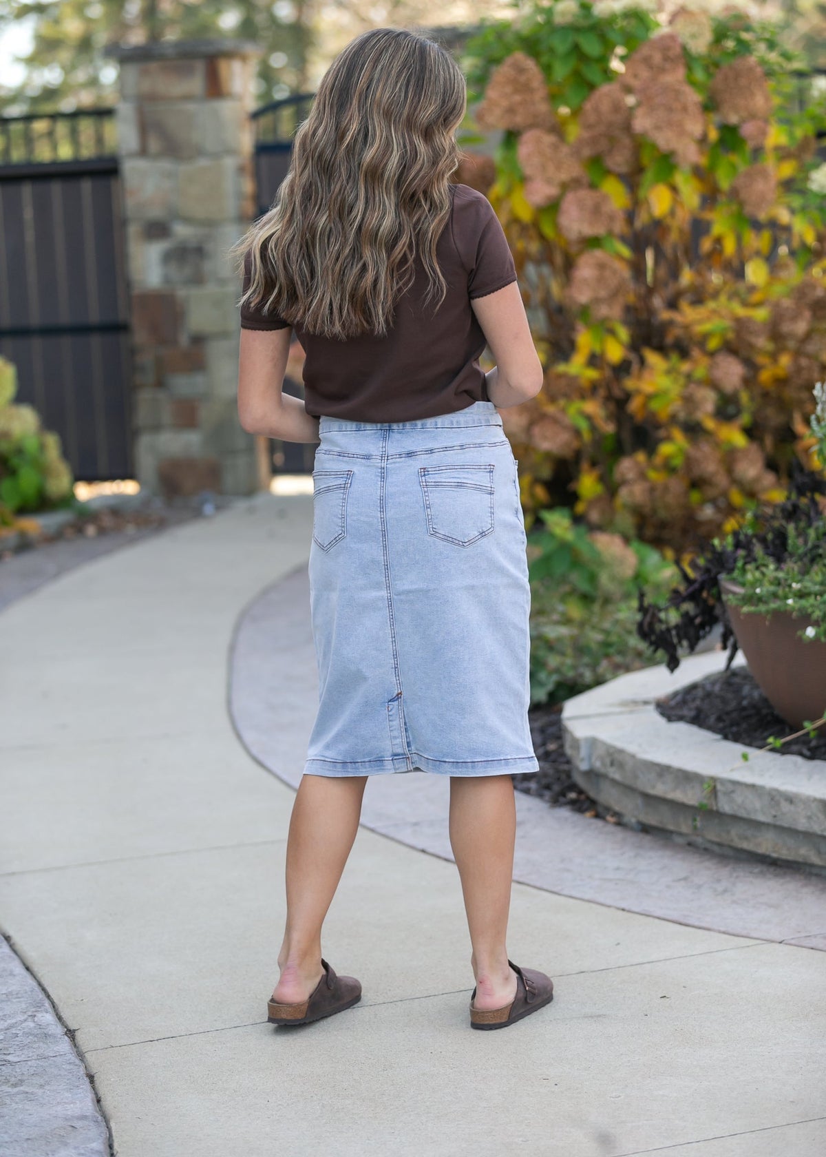 Light wash denim midi skirt from Inherit Co. featuring a classic A-line silhouette and subtle stitching details.