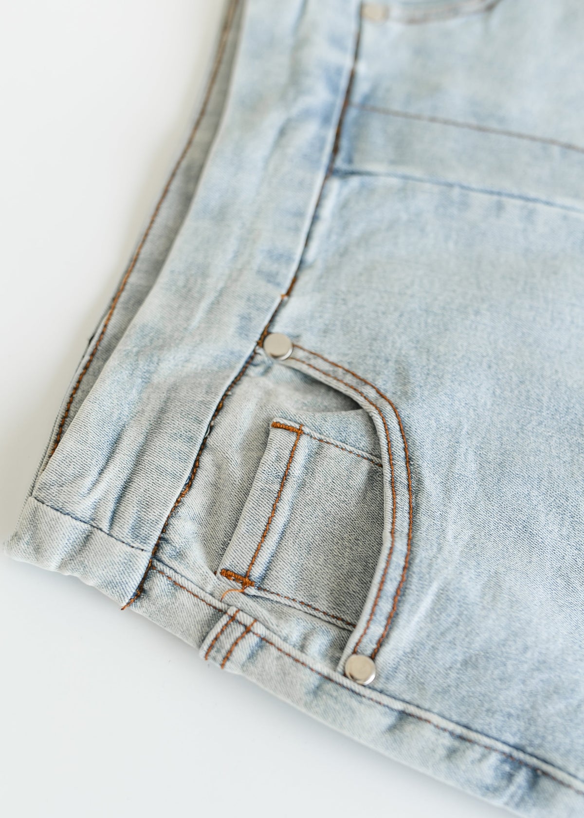 Inherit Co. Sandra light wash denim midi skirt, stylish IC Skirt featuring a classic A-line silhouette and front pockets.